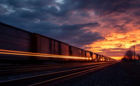Train de marchandises circulant au coucher du soleil, symbolisant l'efficacité logistique de Transglobe.