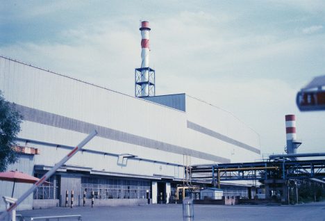 Usine avec structures métalliques et cheminées, illustrant des enjeux de gestion des transports industriels.