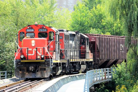 Trains de marchandises en mouvement sur un pont, illustrant l'importance du transport dans la logistique.